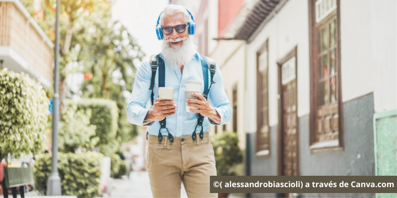 Hombre mayor con cascos de música y móvil
