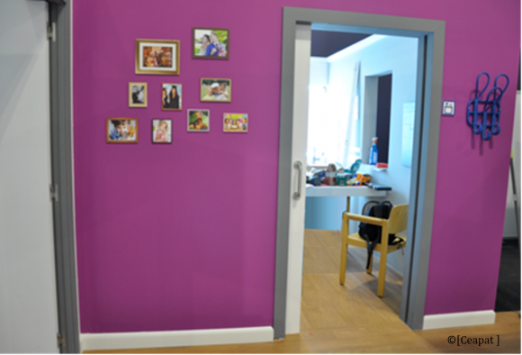 Vestíbulo de acceso con fotos familiares en la pared.