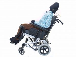 Imagen de maniquí en silla de ruedas basculante inclinada hacia atrás