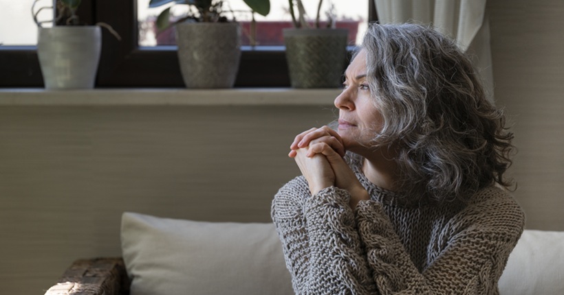 Mujer sentada con mirada triste.